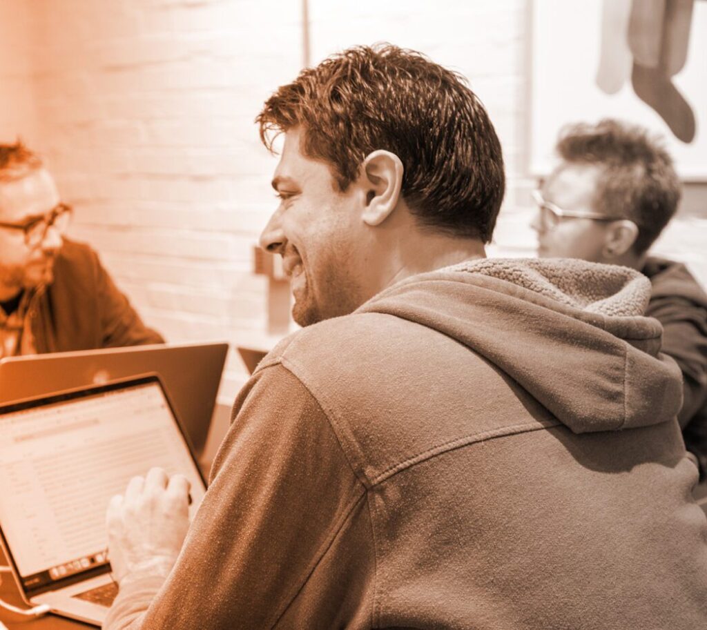 MTTR: Orange gradient over Plandek developer meeting.